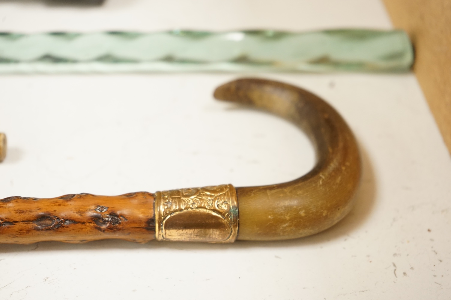 Four walking sticks to include a Brigg of London with carved horn handle in the form of a dogs head and a barley twist glass example, largest 123cm in length